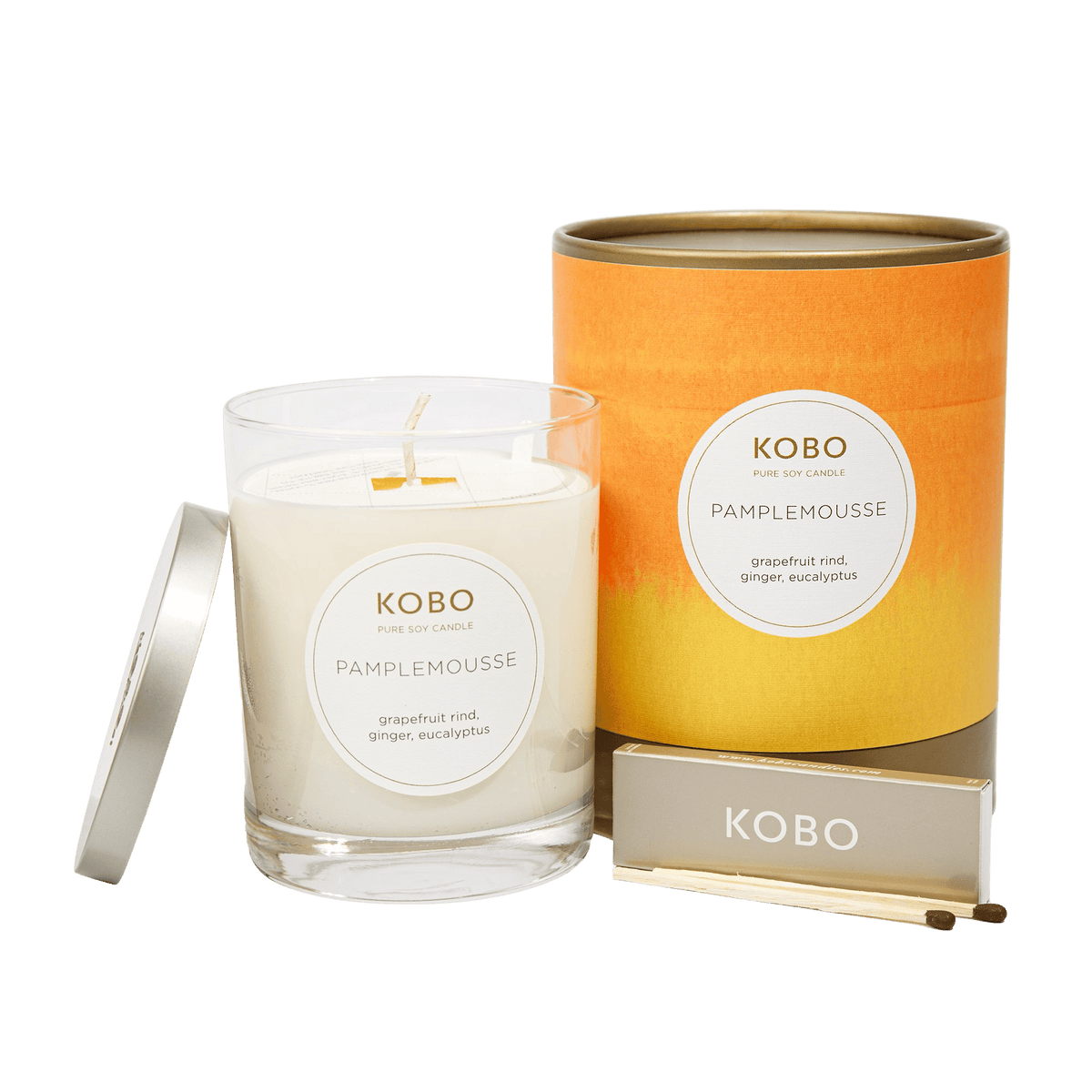 Front view of Pamplemousse Watercolor Candle showcasing grapefruit rind, ginger, and eucalyptus with orange packaging and matches