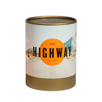 Front view of Highway Road Trip Candle showcasing its highway themed label and pure soy candle text on a transparent background