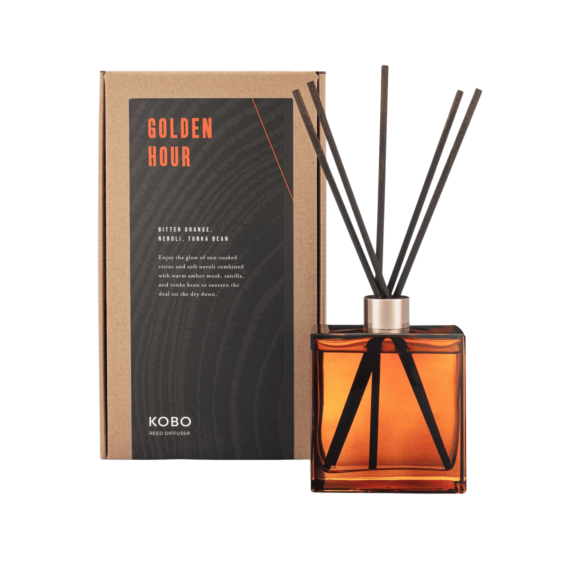 Front view of Golden Hour Woodblock Room Diffuser showcasing an amber glass bottle, black reeds, and product box